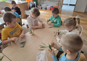 dzieci tworzą koszyczki z sizalu