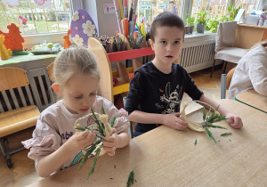 dzieci tworzą koszyczki z sizalu