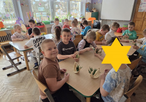 dzieci tworzą koszyczki z sizalu