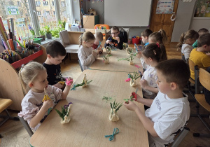 dzieci tworzą koszyczki z sizalu