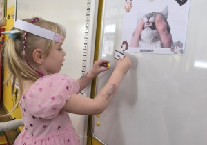 Dziewczynka przyczepia obrazek