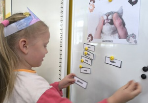 Dziewczynka przyczepia obrazek