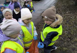 dzieci sprzataja wokol przedszkola