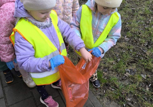 dzieci sprzataja wokol przedszkola