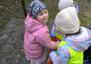 dzieci sprzataja wokol przedszkola