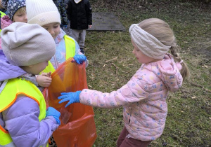 dzieci sprzataja wokol przedszkola