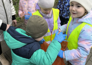 dzieci sprzataja wokol przedszkola