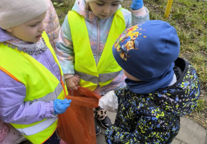 dzieci sprzataja wokol przedszkola
