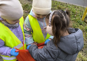 dzieci sprzataja wokol przedszkola