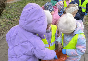 dzieci sprzataja wokol przedszkola