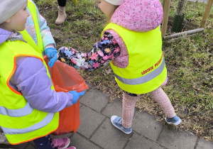 dzieci sprzataja wokol przedszkola
