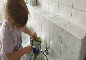 dziewczynka wsypuje sałatę na durszlak