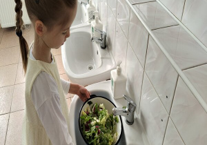 dziewczynka myje liście sałaty