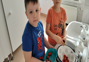 chłopcy z umytymi pomidorkami koktajlowymi