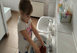 dziewczynka myje pomidorki koktajlowe