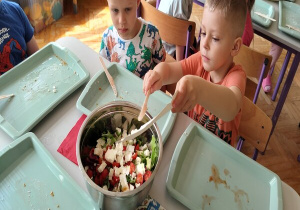 chłopiec zrzuca z tacki pokrojoną cebulkę