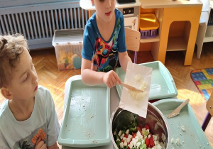 chłopiec zrzuca z tacki pokrojoną cebulkę