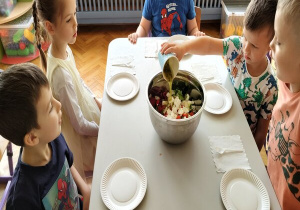 chłopiec wlewa sos grecki