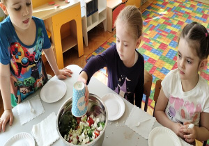 dziewczynka wlewa sos grecki