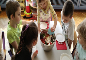 dziewczynka wlewa sos grecki