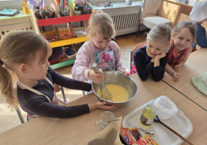 przedszkolaki łączą składniki przygotowując ciasto