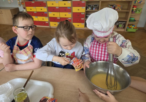 przedszkolaki łączą składniki przygotowując ciasto