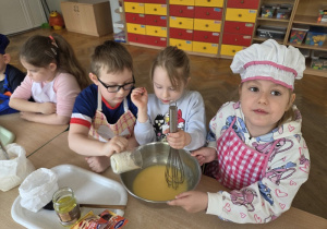 przedszkolaki łączą składniki przygotowując ciasto
