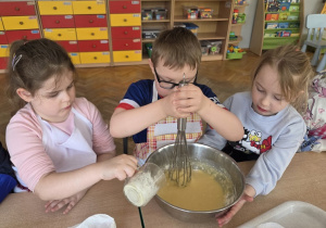 przedszkolaki łączą składniki przygotowując ciasto
