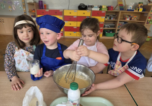 przedszkolaki łączą składniki przygotowując ciasto