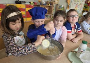 przedszkolaki łączą składniki przygotowując ciasto