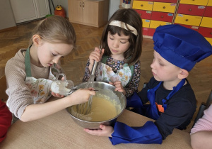 przedszkolaki łączą składniki przygotowując ciasto