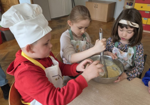 przedszkolaki łączą składniki przygotowując ciasto