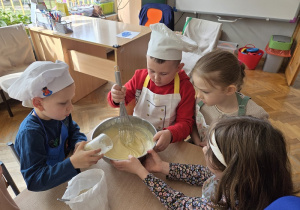 przedszkolaki łączą składniki przygotowując ciasto