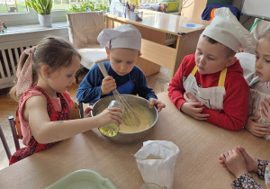 przedszkolaki łączą składniki przygotowując ciasto