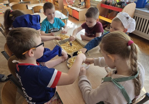 przedszkolaki łączą składniki przygotowując ciasto