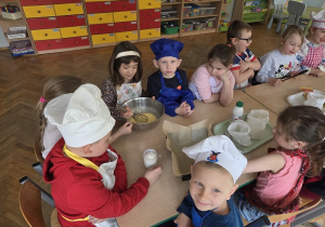 przedszkolaki łączą składniki przygotowując ciasto