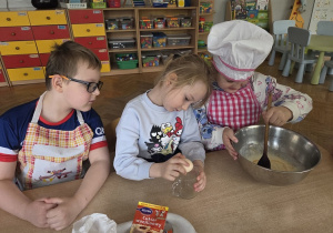 przedszkolaki łączą składniki przygotowując ciasto