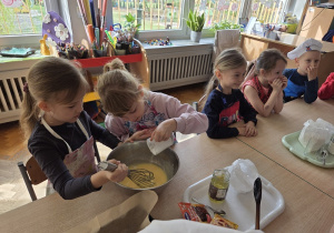 przedszkolaki łączą składniki przygotowując ciasto