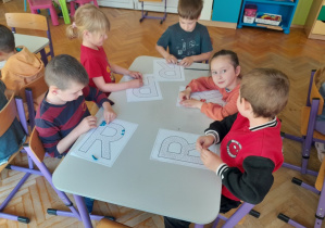 Dzieci wyklejają literę "r" plasteliną