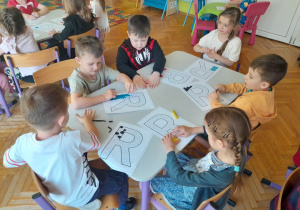 Dzieci wyklejają literę "r" plasteliną