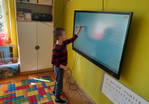Dzieci piszą na tablicy poznaną literę