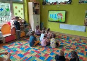 Dzieci oglądają i słuchają piosenki o numerze alarmowym