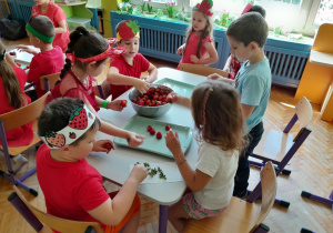 Dzieci odrywają szypułki z truskawek