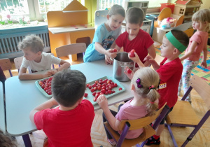 Dzieci przygotowują koktajl truskawkowy