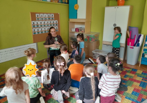 Dzieci słuchają książki czytanej przez Panią Bibliotekarkę