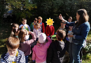 Dzieci sadzą cebulki kwiatowe w przedszkolnym ogródku