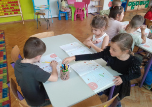 Dzieci wykonują w książkach ćwiczenia utrwalające poznaną literę
