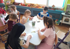 Dzieci wykonują zadanie przy stolikach