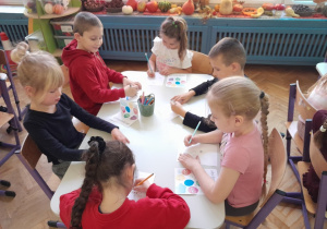 Dzieci wykonują zadanie przy stolikach