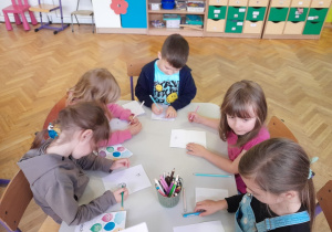 Dzieci wykonują zadanie przy stolikach